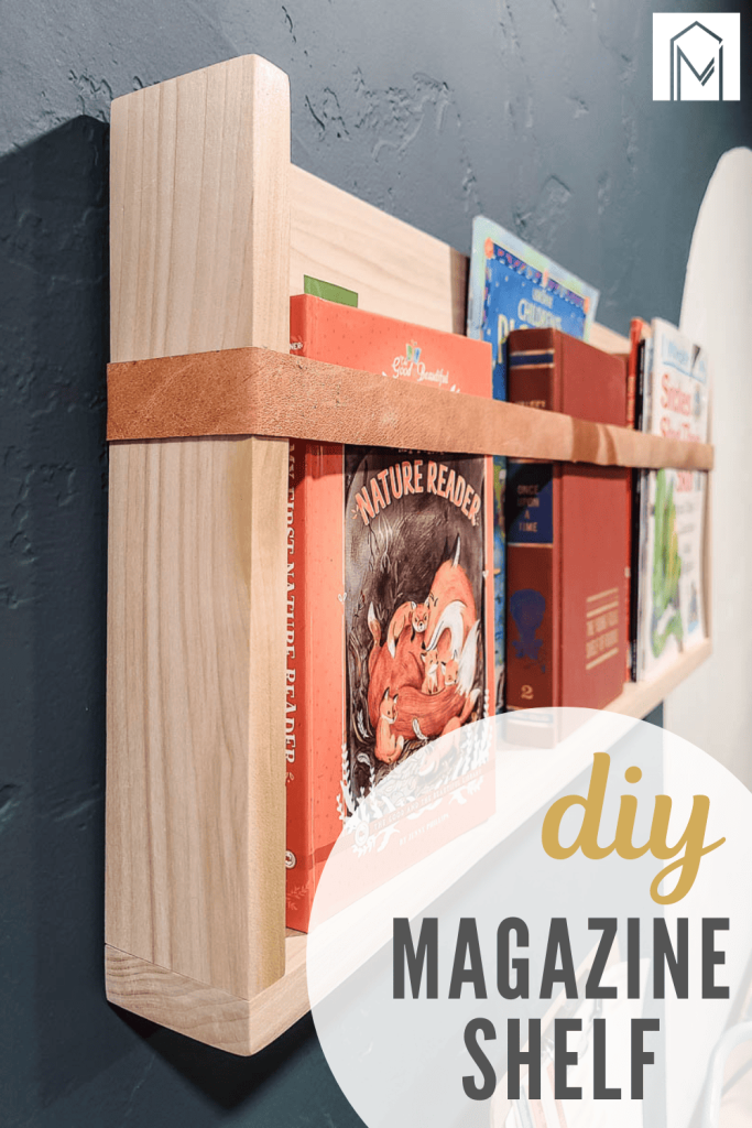 Wooden magazine rack with a leather strap on the front with kids books in it hanging on the wall