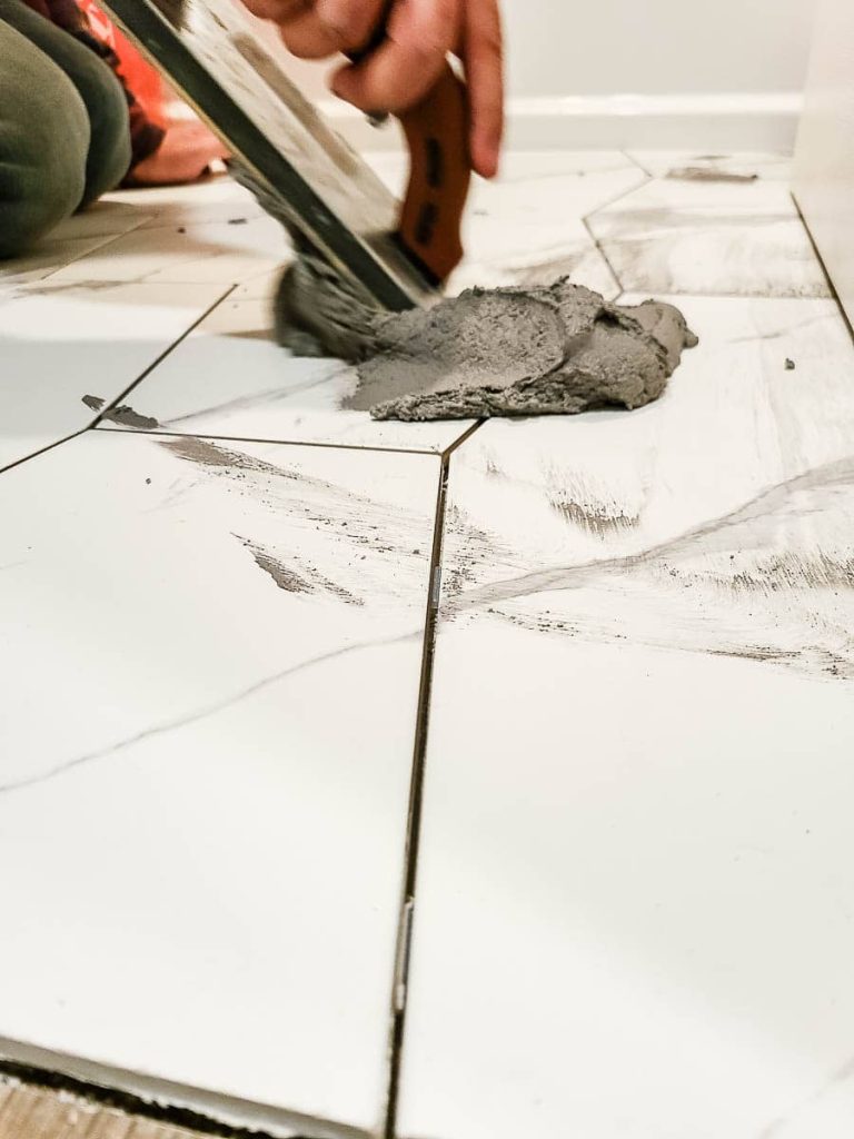 An image completed tile installation with starting to evenly apply grout.