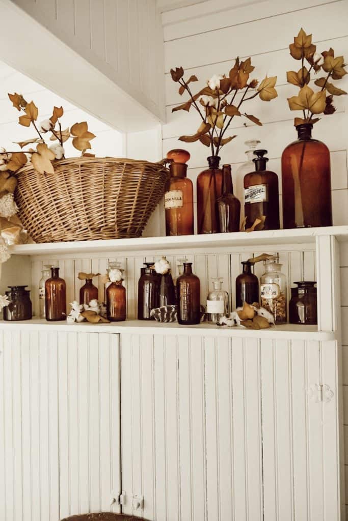 vintage amber glass vases filled with faux fall foliage
