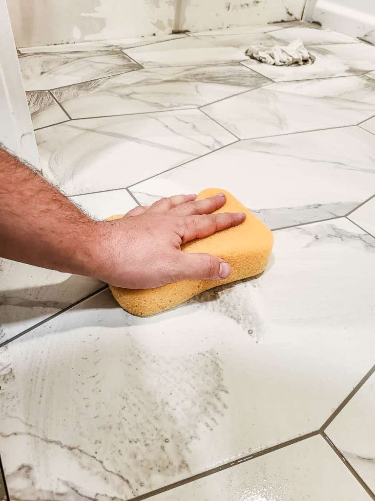 Sponge cleaning tiles post-grouting for a polished finish.