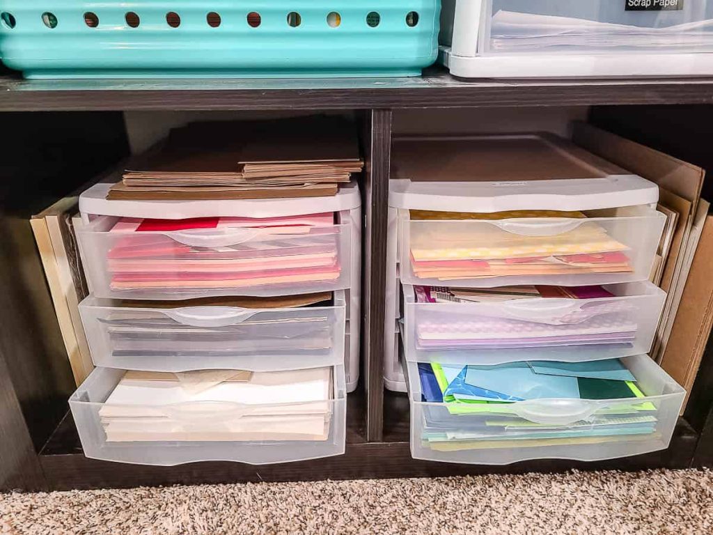 Transparent drawers showcasing neatly organized colored paper and paper scraps, providing easy access to a vibrant and organized collection of creative materials.