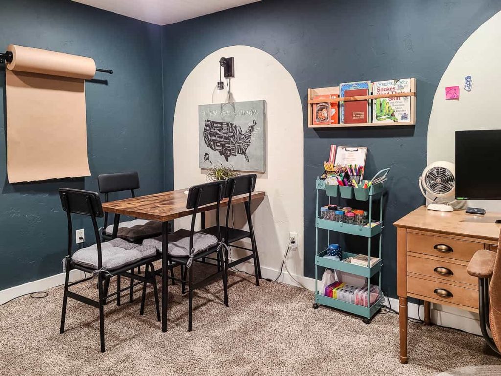Room showcasing a built-in kraft paper holder, ledge shelf adorned with textbooks, along with a cozy couch, table, and chairs, offering a secure and comfortable learning environment.