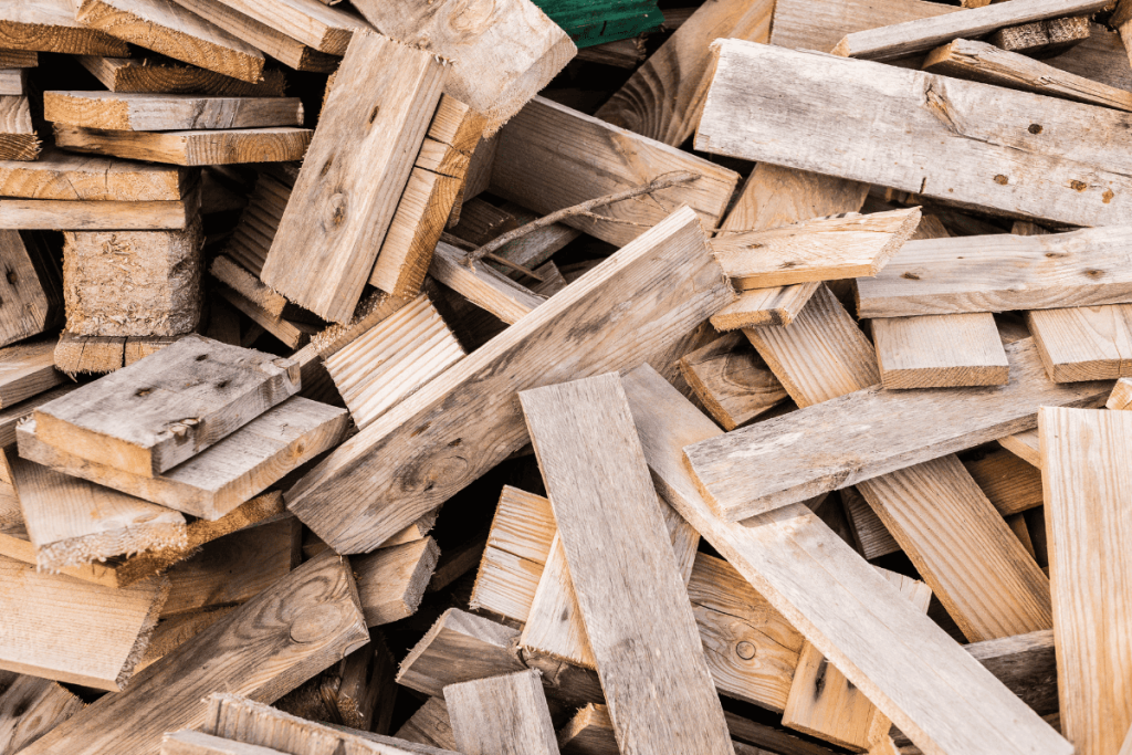A pile of dismantled wooden pallets can be repurposed into a DIY pallet shelf.