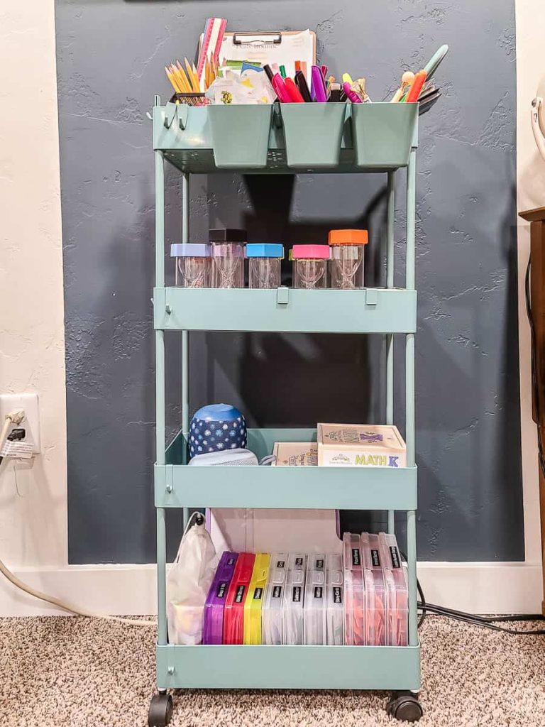 An arrangement of miscellaneous objects in a well-structured rolling cart organizer for homeschool supplies