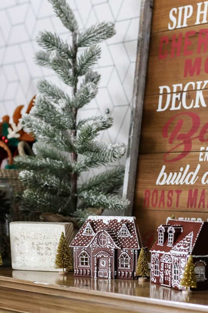 A close-up view of a festively decorated shelf, showcasing a charming DIY gingerbread house surrounded by an abundance of Christmas decor. Delightful ornaments, twinkling lights, and intricate details of the gingerbread house create a heartwarming and festive scene.