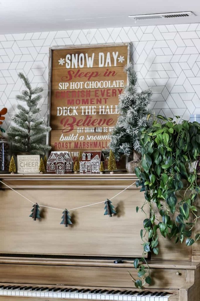 A festive holiday shelf adorned with an array of Christmas decorations, featuring a handmade DIY gingerbread house as the centerpiece. The shelf is filled with cheerful ornaments, sparkling lights, and seasonal joy, creating a warm and inviting holiday display.