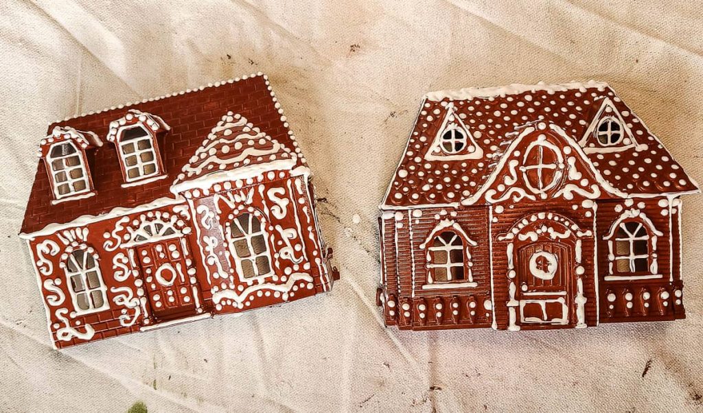 Two dollhouses showcasing the final result of white puffy paint decoration, adding a snowy and textured charm for festive holiday vibes.