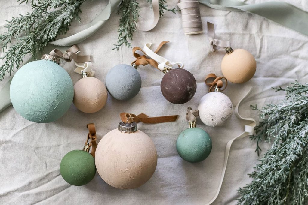 A photo of textured ornaments with ribbon on top.