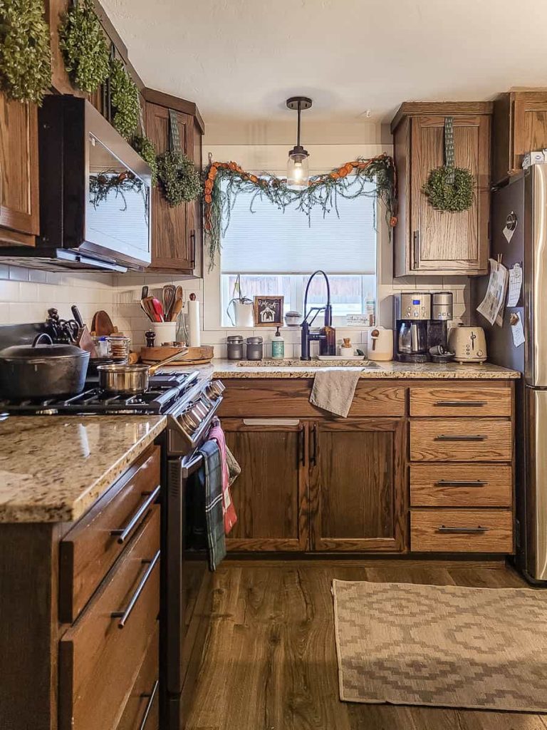 A mini wreath has been placed on the kitchen cabinets for Christmas season.