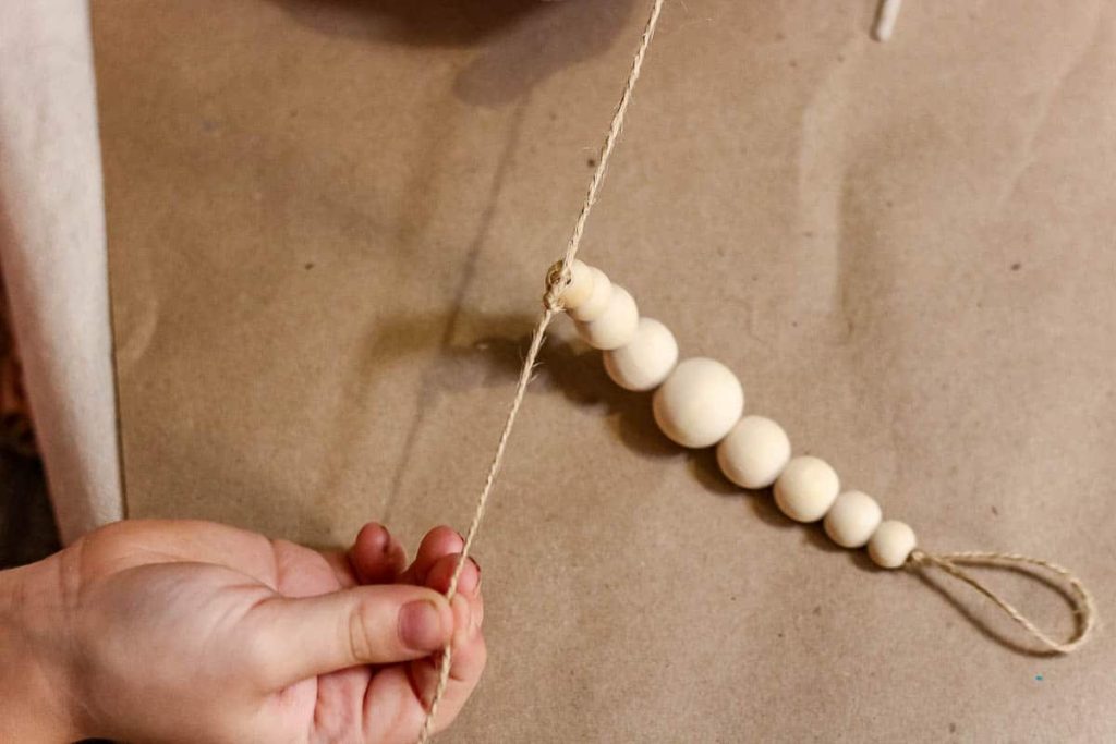 The beads are attached, and then the person is tied with an overhand knot.