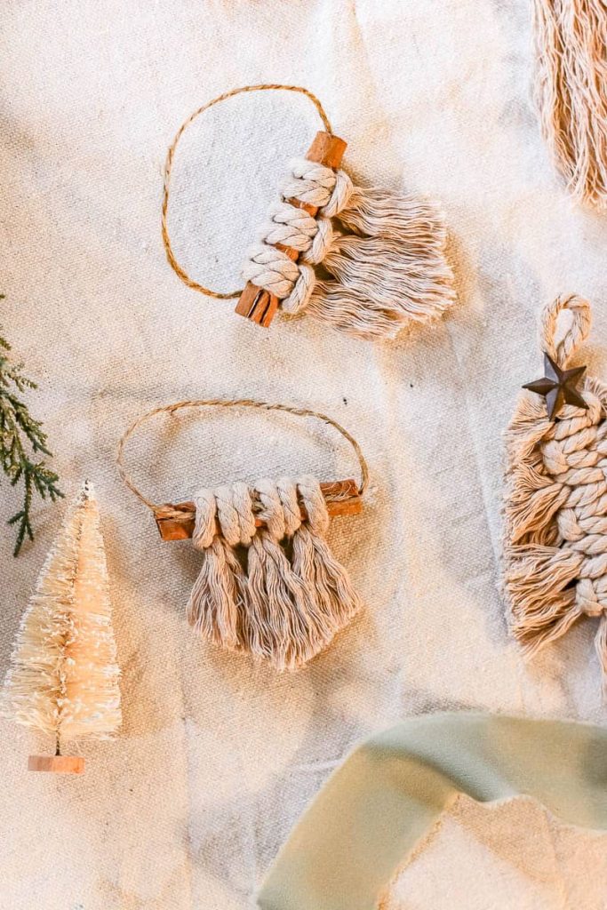 2 Macrame Christmas Ornaments, finished in a boho-style cinnamon stick design.