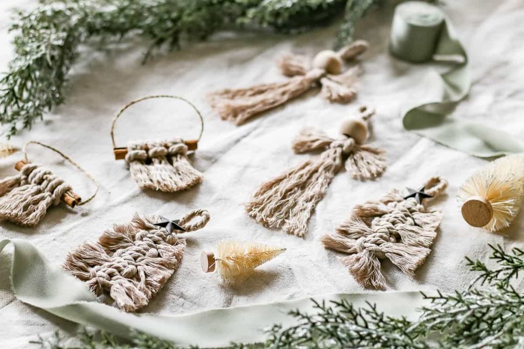 Three Macrame Christmas Ornaments are placed on the ground in a photo.