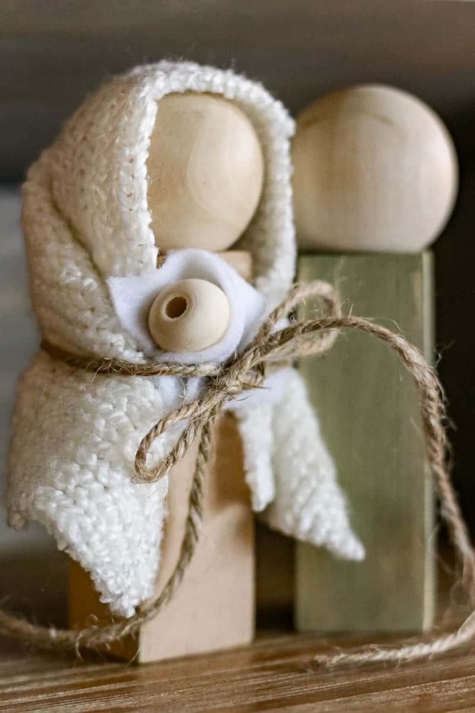 Two Woden dolls, Mary and Joseph, with a baby Jesus form this DIY Wood Nativity Scene.