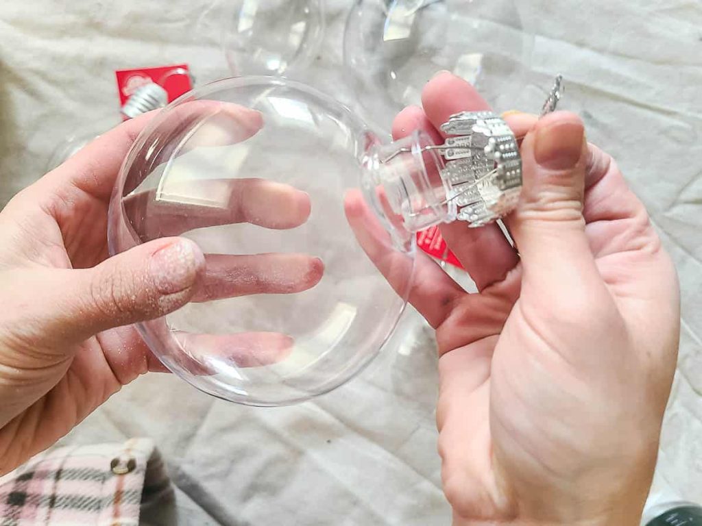 A person is holding a clear ornaments.