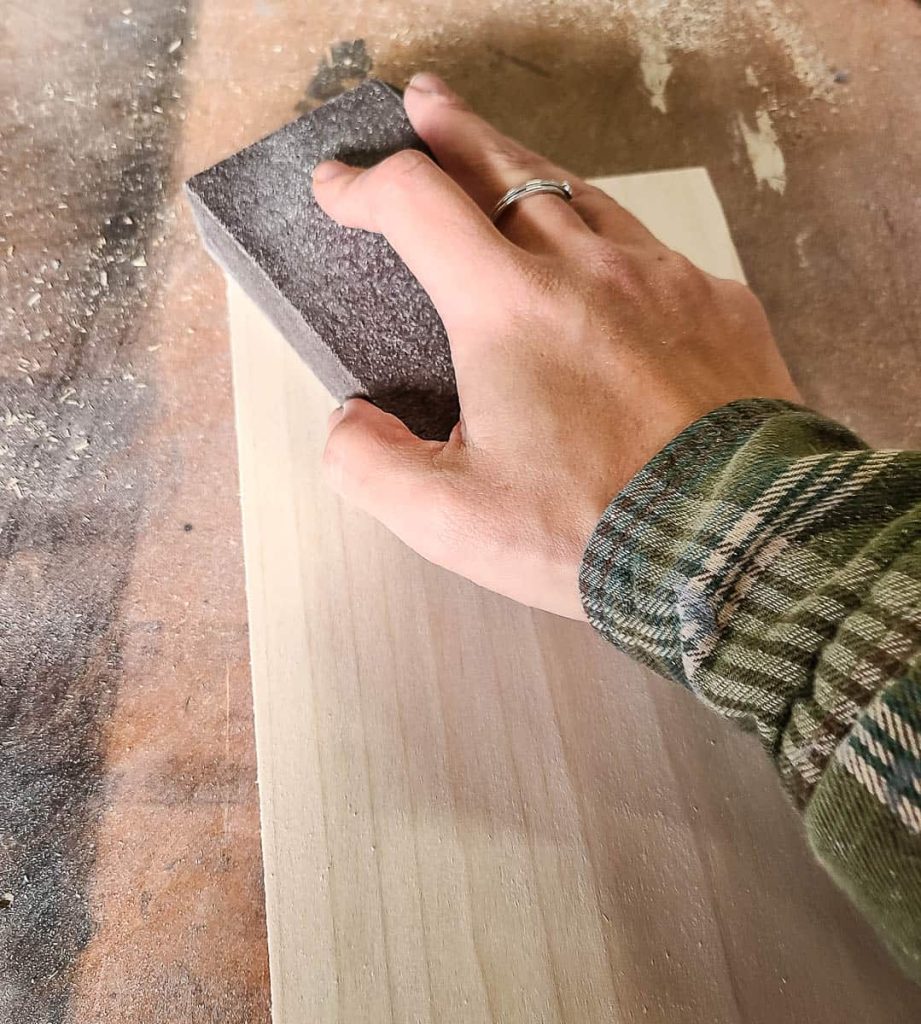A person is sanding a wood.