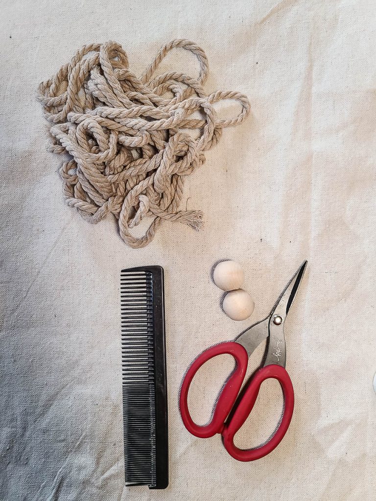 Supplies needed for macrame angel ornament scissor, wooden beads, comb and cord.