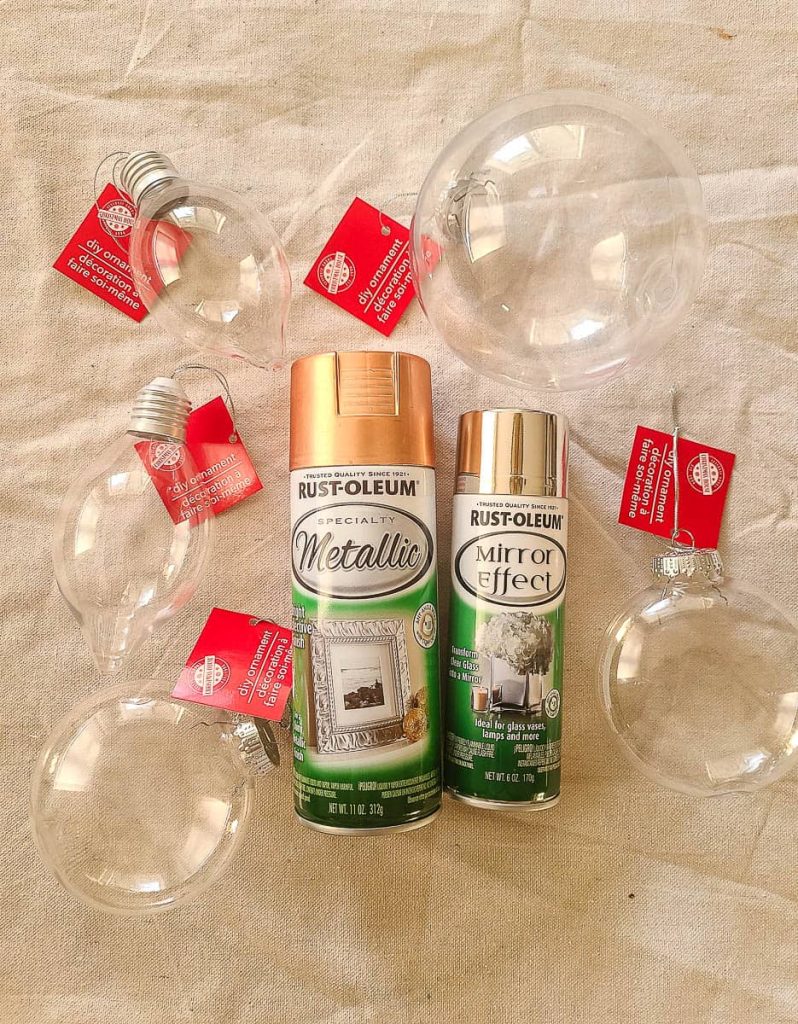 A photo of 6 plastic ornaments and 2 cans of spray paint.