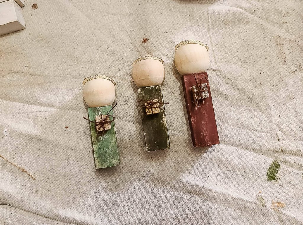 Three handmade wooden dolls lay for DIY Wood Nativity Scene.