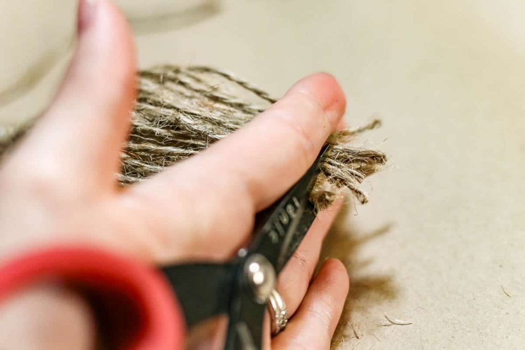 A picture of a person trimming the end off a twine.