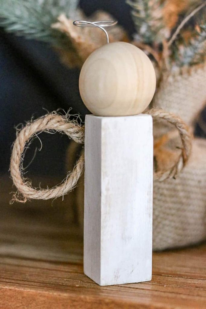 A photo of 1 white doll that looks like an angel, is made out of wood.