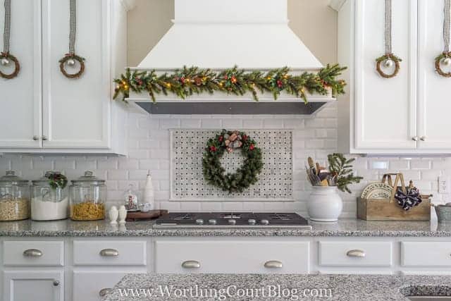 A white kitchen decorated with Christmas mini wreaths.