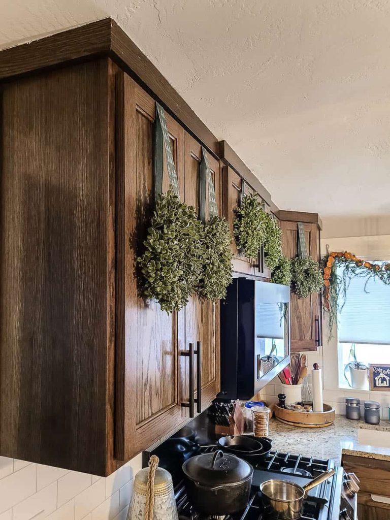 A wreath hangs on the cabinet in the kitchen.