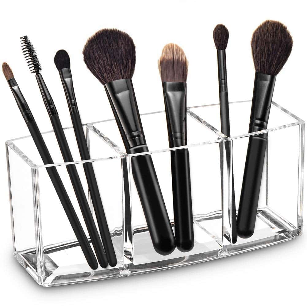 Makeup brushes elegantly arranged and standing upright in an acrylic organizer, providing a visually appealing and organized storage solution for beauty essentials.