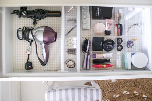 A visually pleasing image of well-organized drawers showcasing compartments for hairstyling tools, hygiene essentials, and makeup, creating an efficient and tidy storage solution for daily beauty and grooming needs.