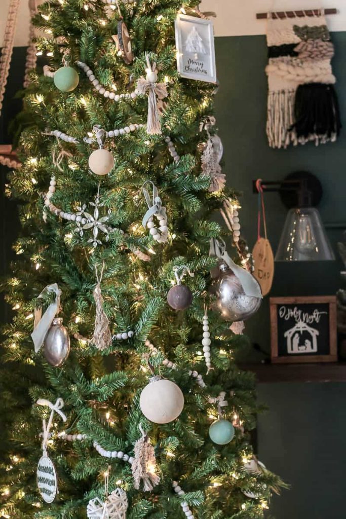 A beautifully adorned Christmas tree with boho-inspired decorations, featuring twinkling lights that add a touch of magic to the eclectic and festive holiday setting.