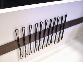 Bobby pins securely organized on magnetic strips inside a drawer, offering a clever and efficient storage solution for easy access and a clutter-free environment.