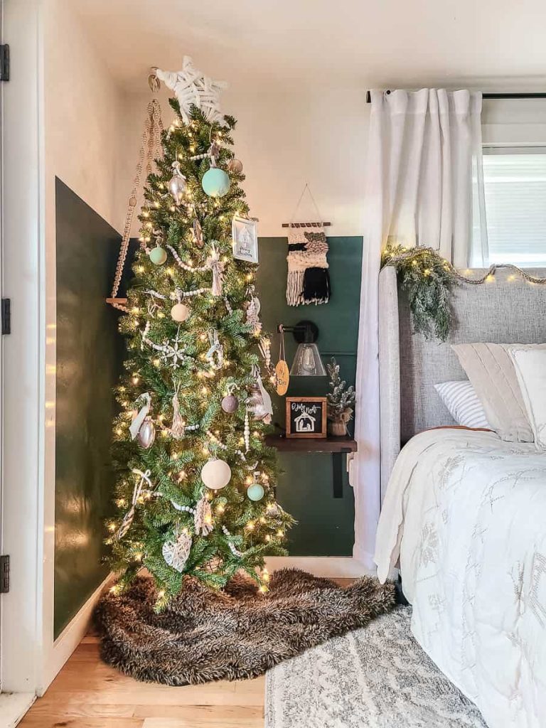 Transformed bedroom into a festive haven with a stunningly decorated Christmas tree surrounded by charming holiday decorations, evoking a cozy and magical ambiance