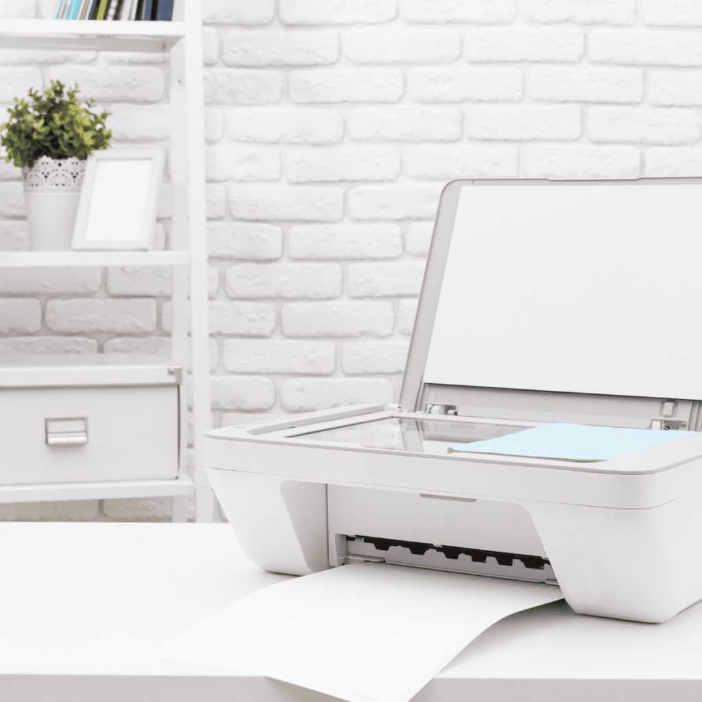 Home printer sitting on white desk countertop with white brick wall in background 