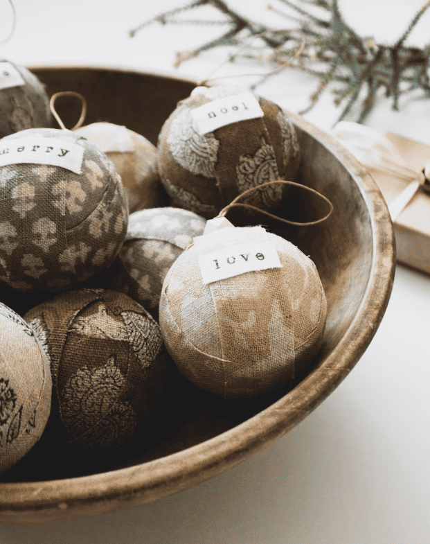 A close-up view of a Christmas tree adorned with elegant linen ornaments, showcasing refined textures and neutral tones for a sophisticated and timeless holiday display.