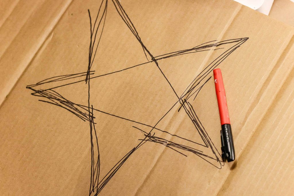 A drawing of a star on cardboard with a marker.