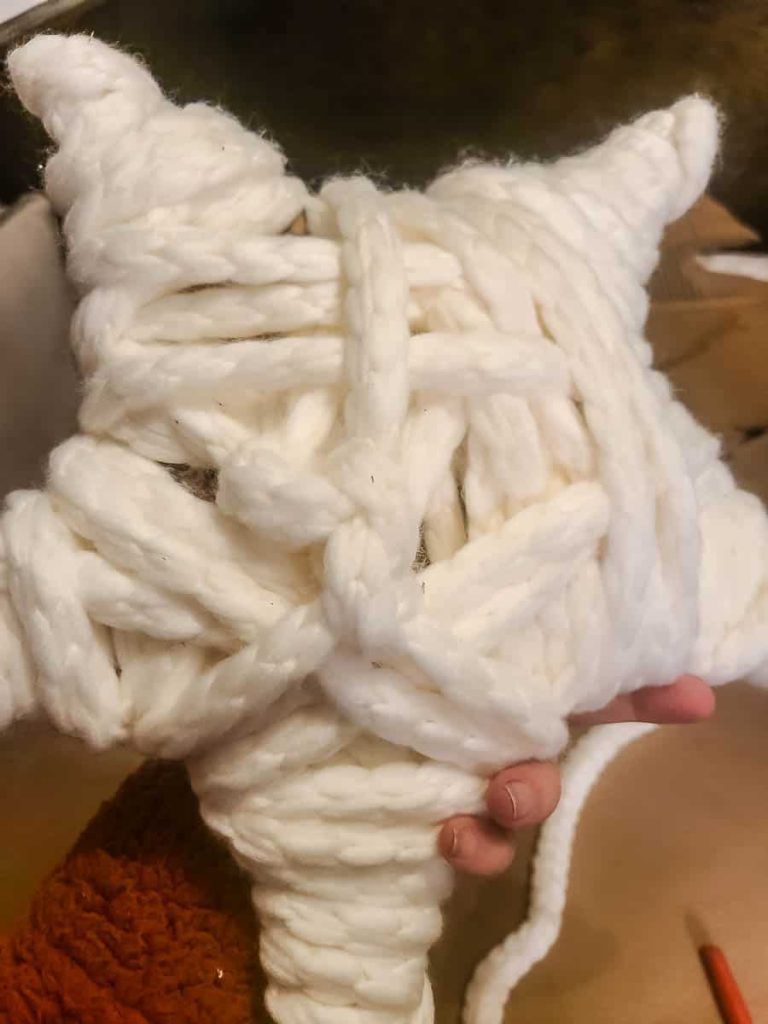 A star was built out of cardboard and covered with yarn. A step on how to make a christmas tree star.