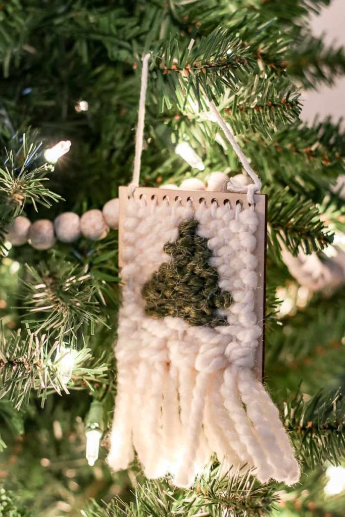 A close-up view of a Christmas tree adorned with a beautifully woven ornament, showcasing intricate patterns and textures, adding a touch of handmade charm to the festive holiday display.