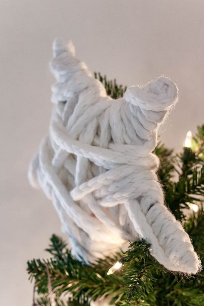 A close-up view of a charming macramé star nestled within the branches of a Christmas tree, adding boho elegance and handmade charm to the festive holiday decor.