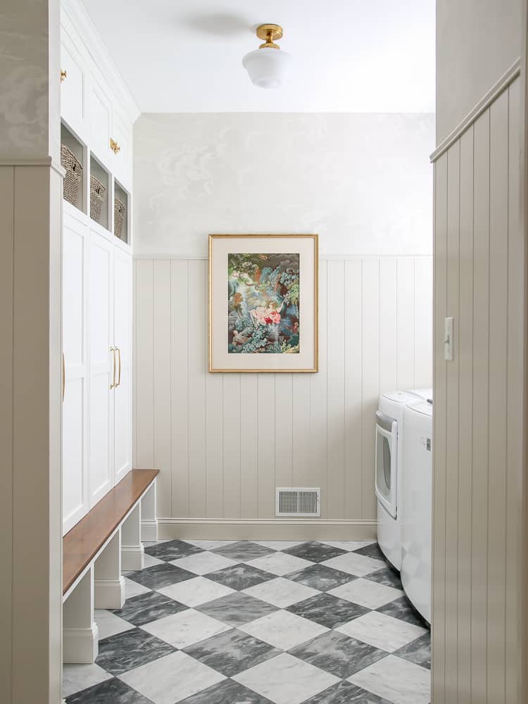 checkered tile floor in a laundry area with beige vertical shiplap walls and built-in lockers 