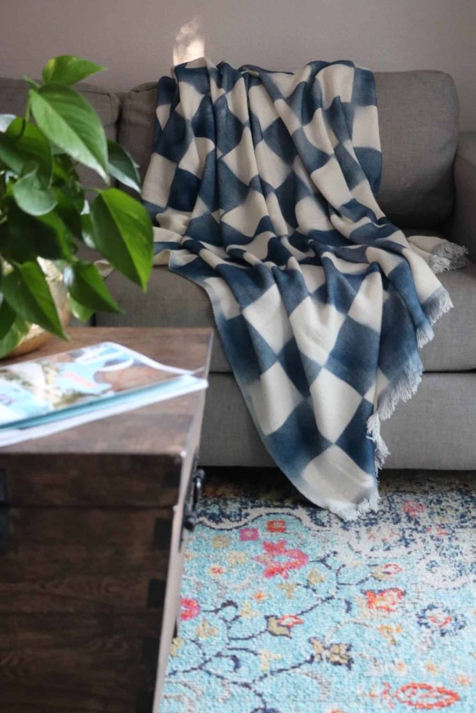 A Painted Throw Blanket with Check Pattern laying on a couch