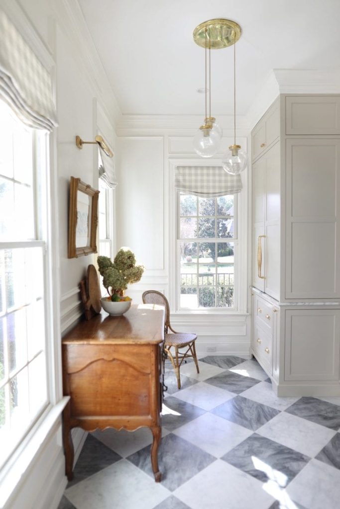 Walk in butlers pantry with gray and white marble tile floor in checkered board pattern
