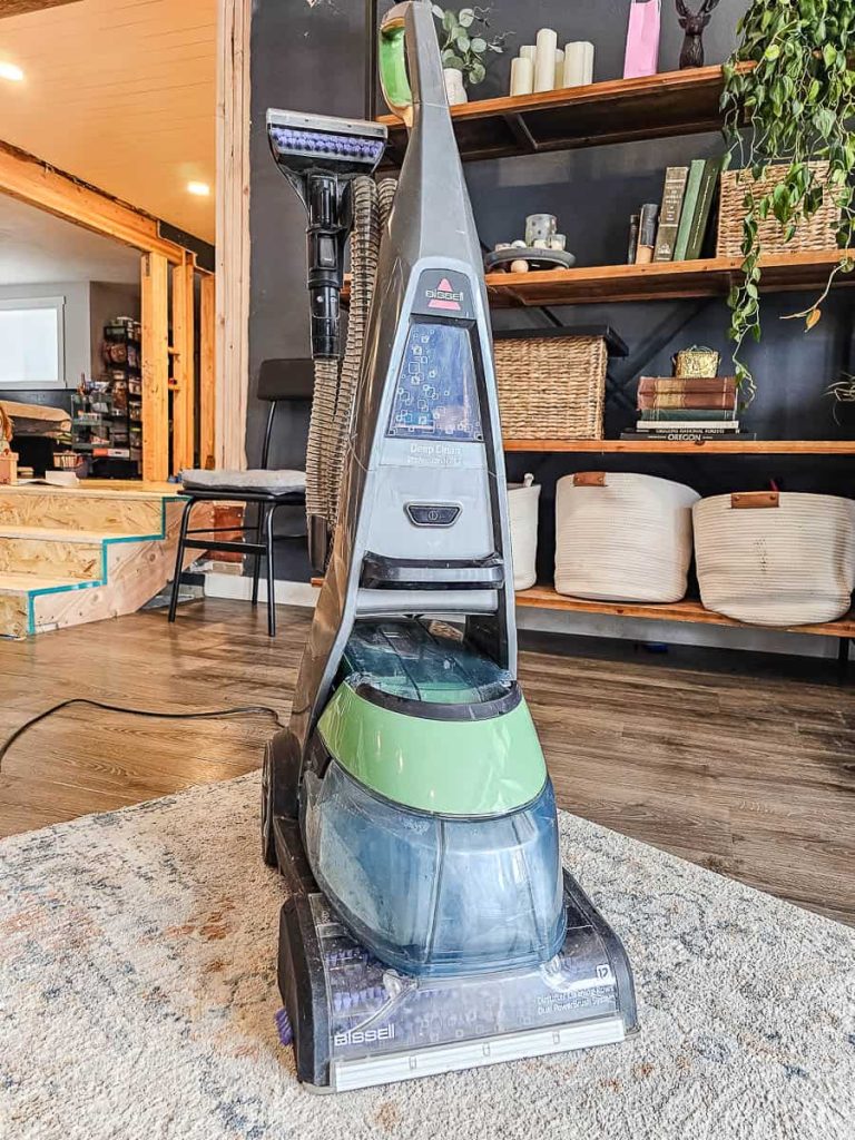 A carpet cleaner is being used in the living room.