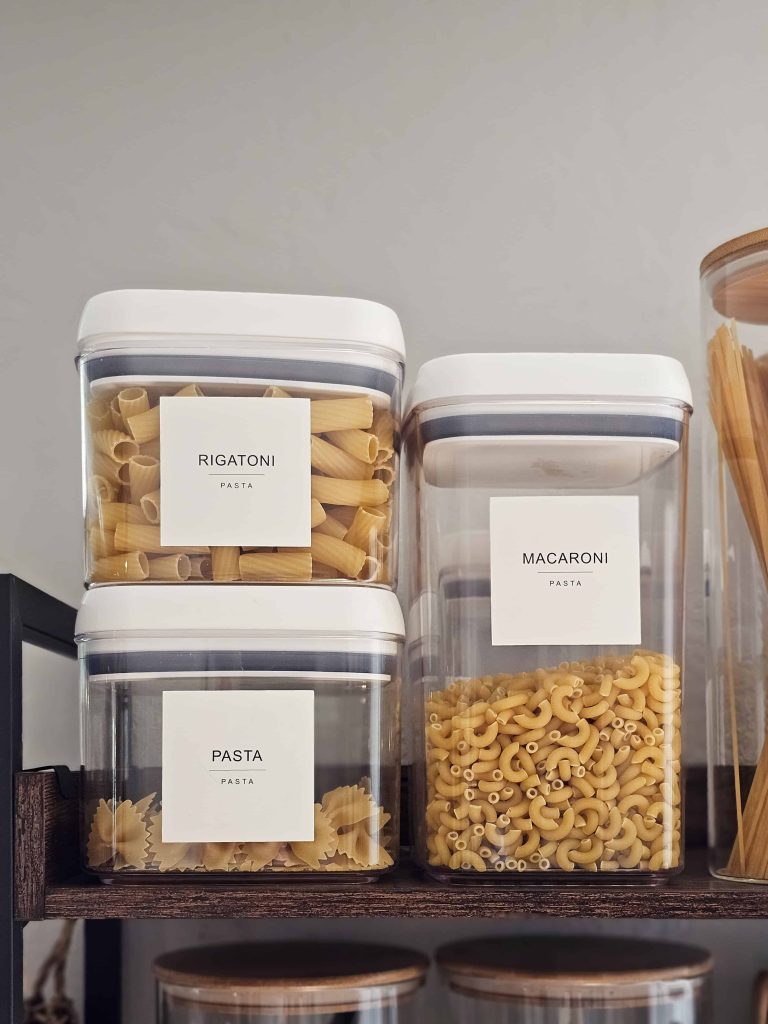 Pasta stored in food containers placed on the shelves.