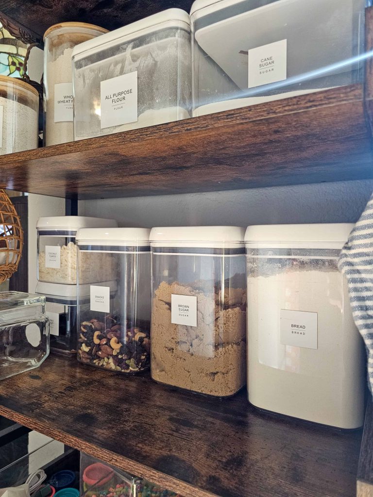 An image featuring a shelf adorned with food storage containers and assorted dry goods neatly arranged on it.