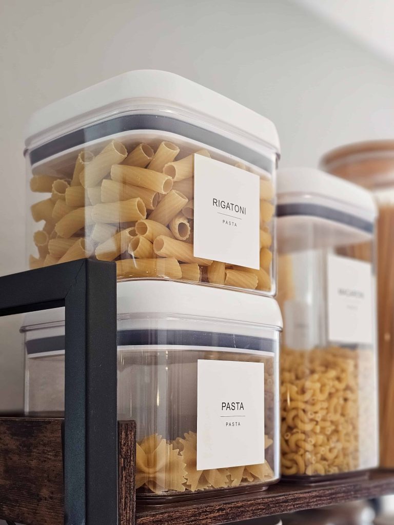 A snapshot featuring shelves with food storage containers filled with pasta.