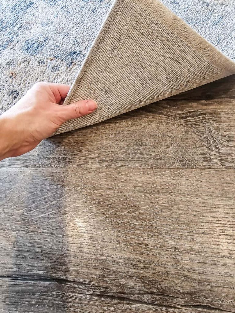 A person is holding a rug in the photo.
