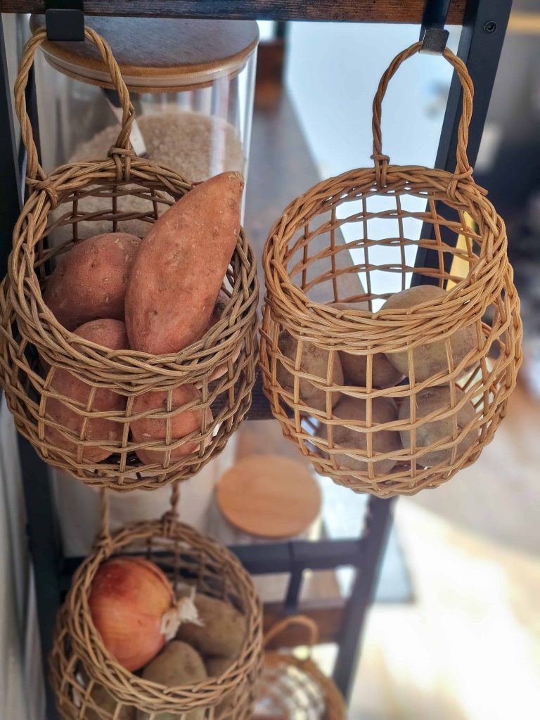 A basket with a potato placed beside the shelves.