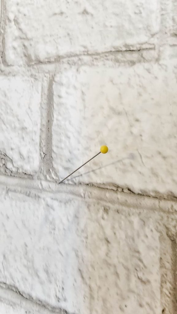 Wallpaper in the wall with a pin.