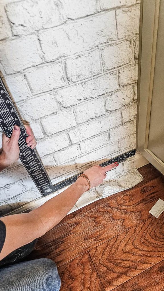 The finishing touches as a person trims the edges of the wallpaper for a clean and polished look.