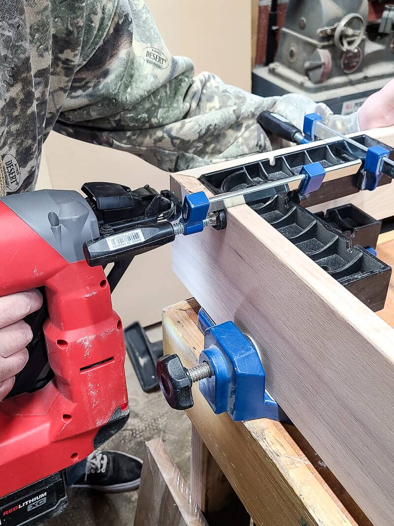 A person is using tools to assemble the sofa table for their Behind-the-Couch Table with Outlet project.