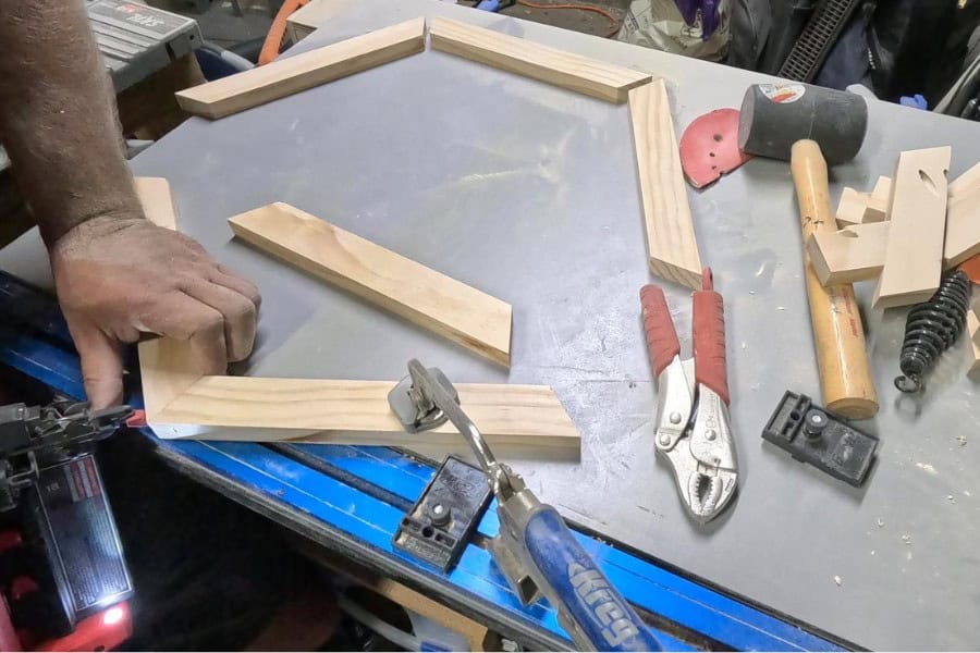 The man is gluing and securing the table to ensure stability.